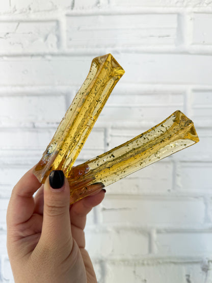 Hand holding two pork parsley collagen dental chews for dogs